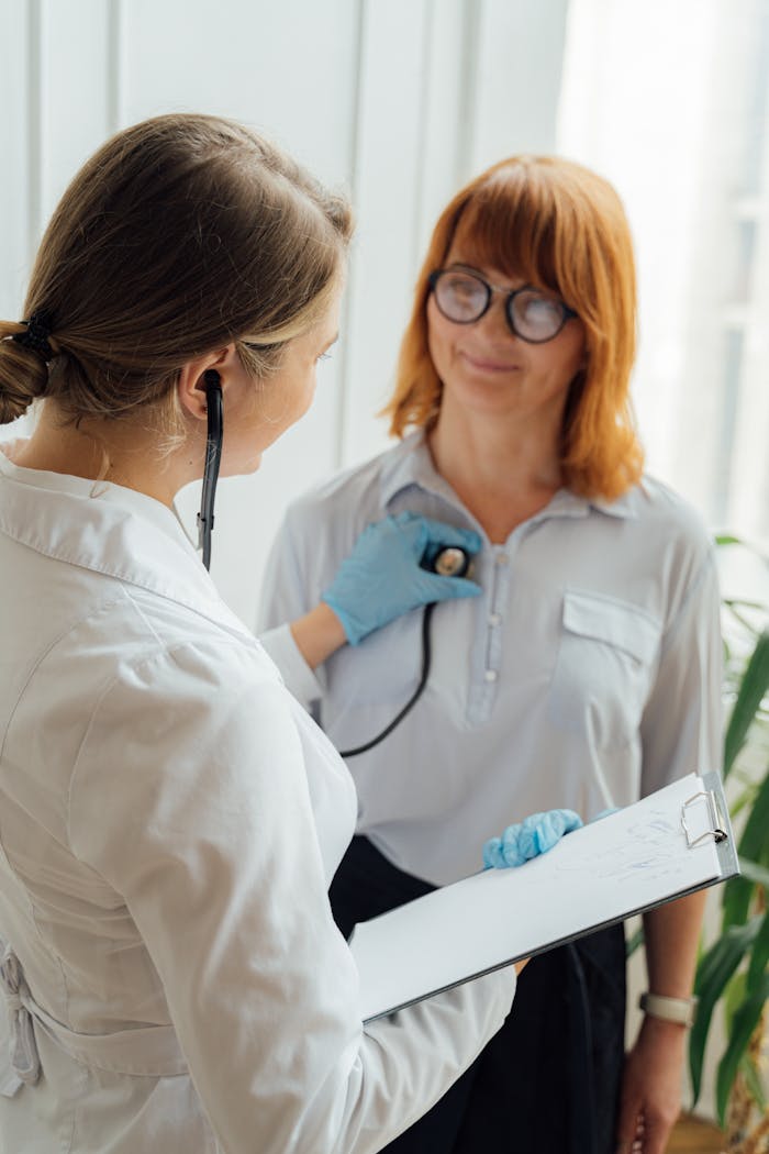 Doctor with stethoscope performing checkup on patient indoors.