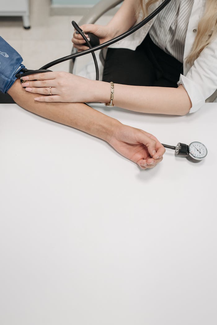 A medical practitioner checking a patients blood pressure in a clinical setting.